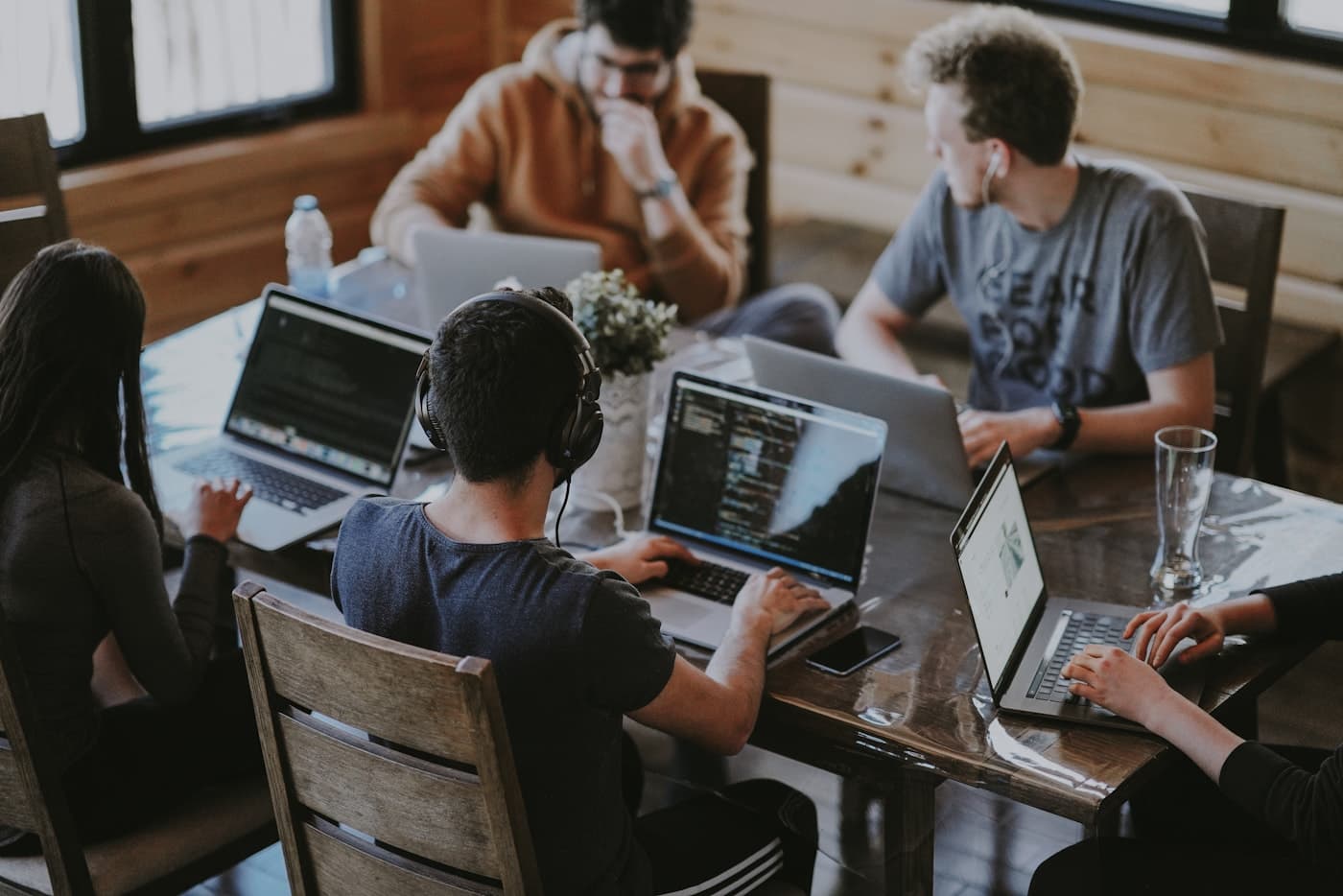 Team members planning together at a table with laptops